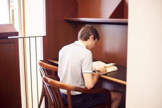Graduate student reads in a study carrell.