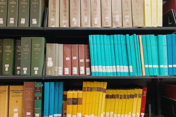 Shelved books with multicolored binding.