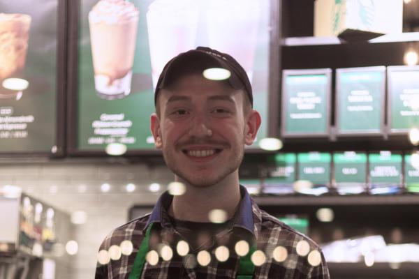 Barista at Starbucks smiles behind the counter.