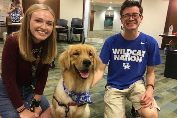 Two students attend an event with the 4PAWS organization in the Hub at Young Library.