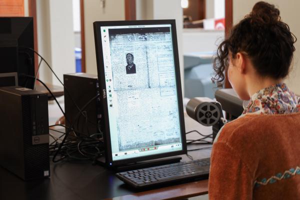 Student uses microform reader on the second floor of Young Library.
