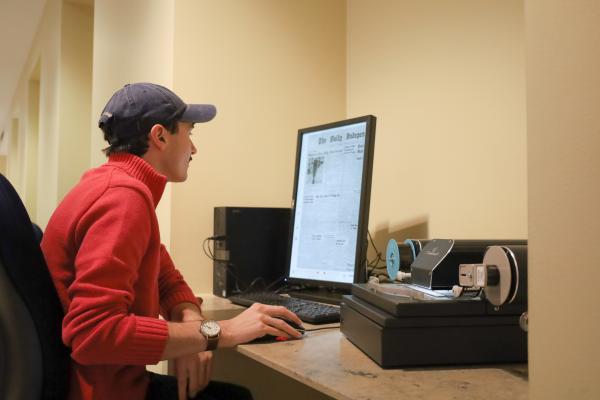 Student uses microform reader on the First Floor of Young Library.