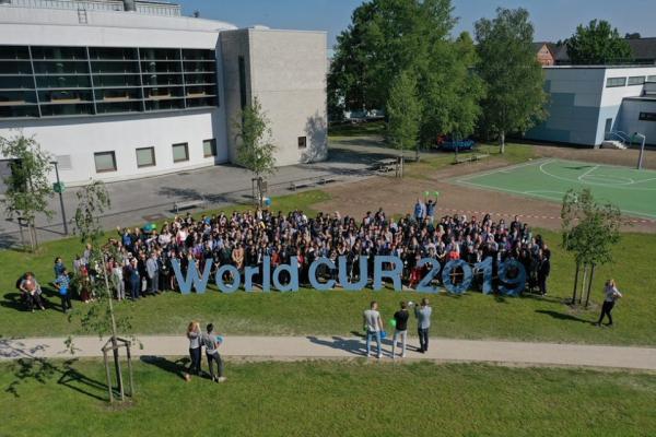Students stand near the WorldCUR 2019 sign in Oldenburg Germany.