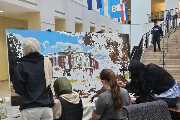 Students paint a mural in the lobby of William T. Young Library
