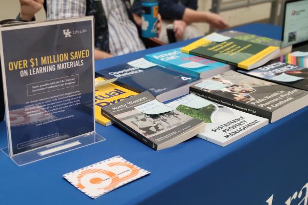 Open textbooks on a table with a sign advertising student savings