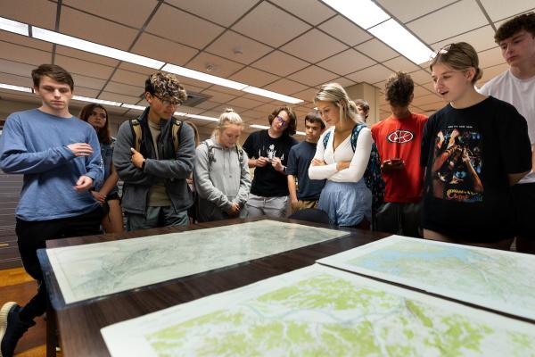 Patrons look at maps on a table