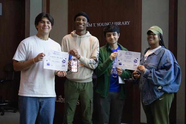 Four UK students pose with certificates for their winning film