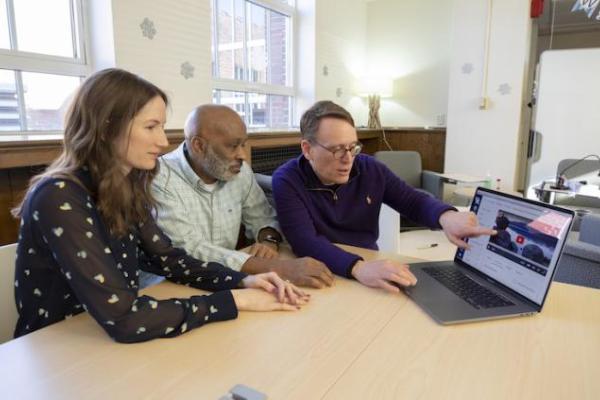 CELT employee showing instructors a tool on a laptop.