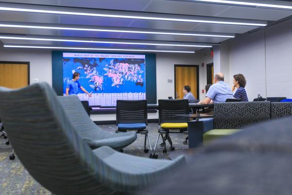 A student gives a presentation using a visualization wall