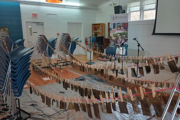 Archival materials hanging by clothespins during restoration