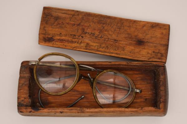 A pair of glasses in a handmade wooden case