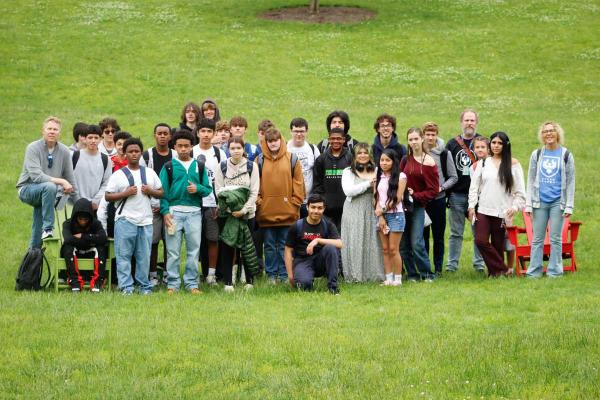 A large group photo of STEAM Academy students standing in the grass