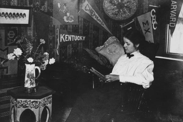A student reads in her dorm room under banners adorning the walls