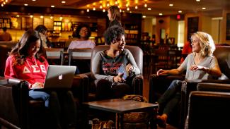 Three students study in Starbucks at Young Library.