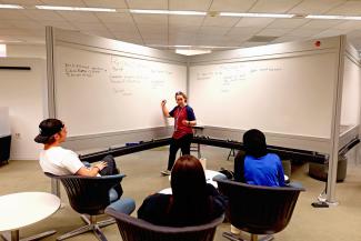 Students use the white board walls for a group study session on the Second Floor of Young Library.
