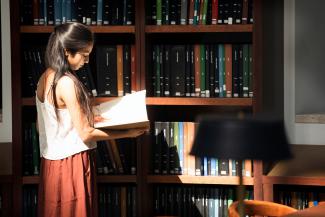 A student browses the journal collection on the Third Floor of Young Library.