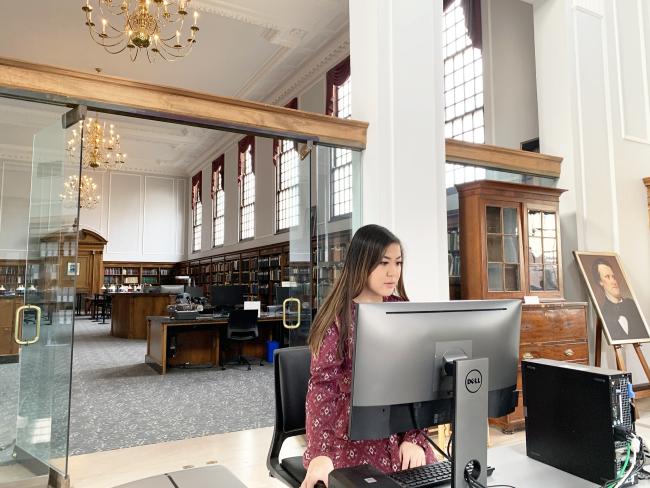 A student stands in front of a computer in the Breckinridge Digital Studio