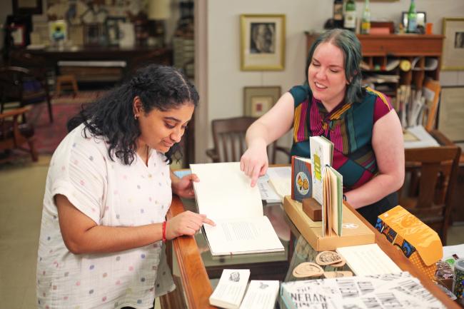 Two King Library Press apprentices reading a hand-made book