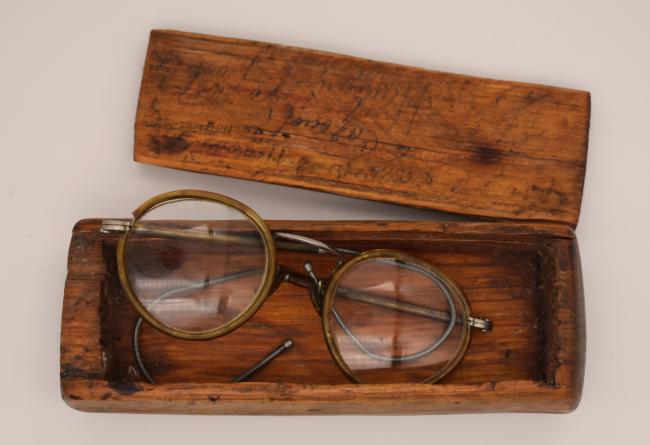 A pair of glasses in a handmade wooden case