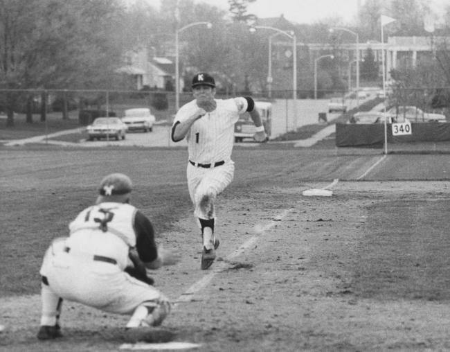 A University of Kentucky baseball player runs toward home plate as a catcher blocks