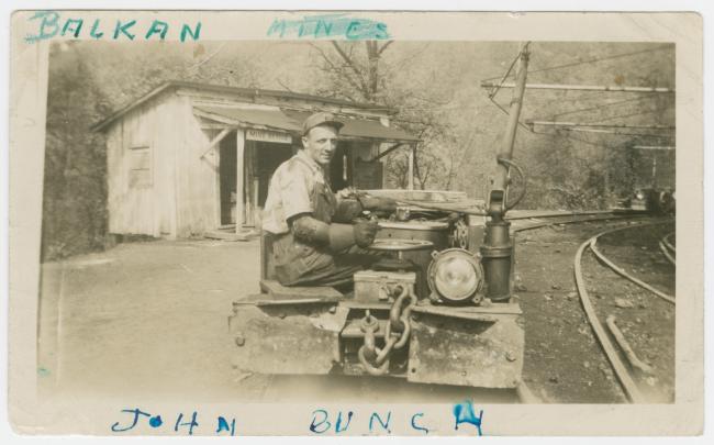 Archival photograph depicting miner John Bunch using mining equipment 
