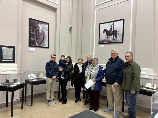 Photograph of eight members of the Walters family in front of display cases at the Balkan exhibit
