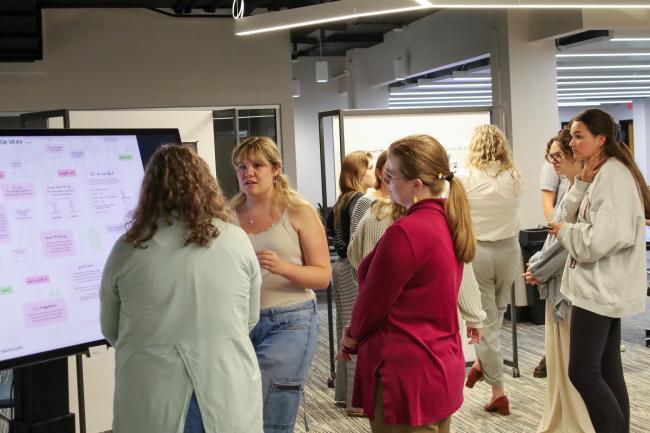 Students stand in front of printed data visualizations