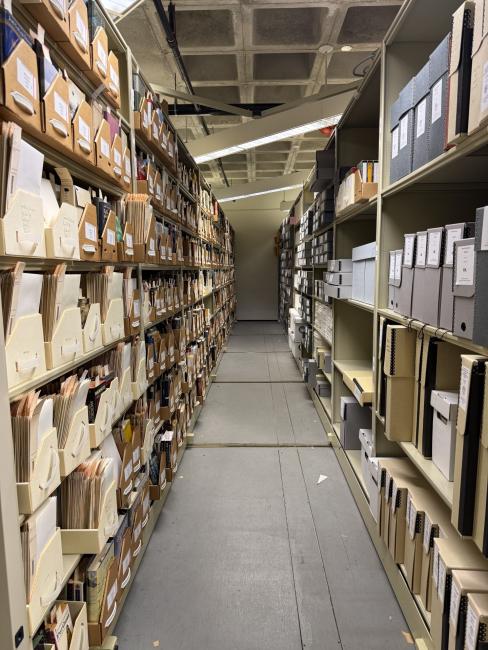 Two full shelves in King Library lined with manuscripts and boxes