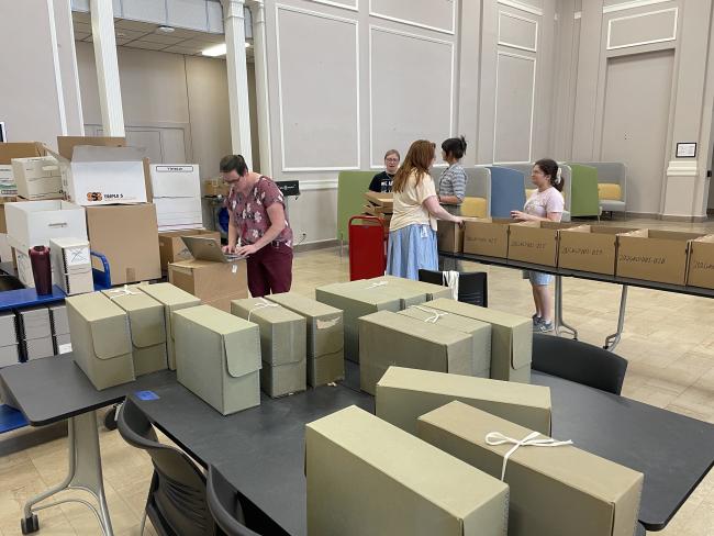 Librarians fill and move boxes of materials