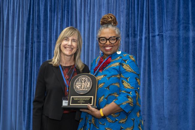 Crystal Wilkinson poses with Annette Debo and holds up the Medallion for Intellectual Achievement