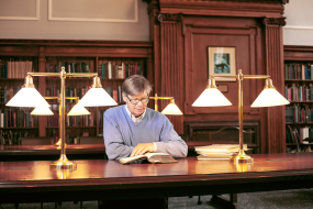Researcher looking at rare books at a table in the Special Collections Research Center.