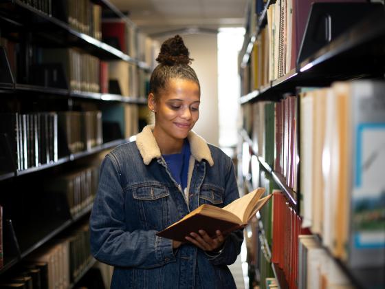 A student browses the print collection in Young Library