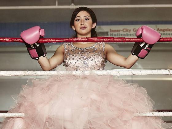 Female poses in quinceañera dress and boxing gloves in boxing ring as promo for HBO's "A Quinceañera Story" part of Film's on Demand's World Cinema Collection.
