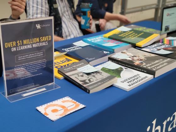 Open textbooks on a table with a sign advertising student savings