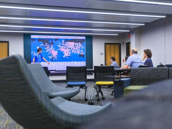 A student gives a presentation using a visualization wall