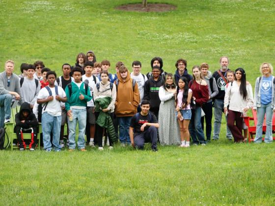 A large group photo of STEAM Academy students standing in the grass