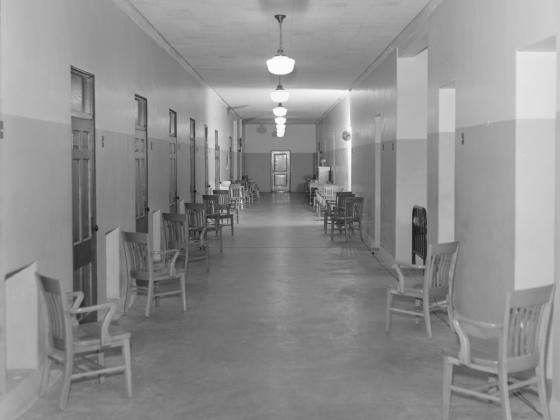 A hallway of the Eastern State Hospital with chairs along the walls