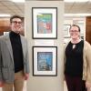 Jack Swab and Colleen Barrett stand near framed images in the Lobby of the Special Collections Research Center.