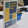 A sign on a table reads "Online. Digital. Free."